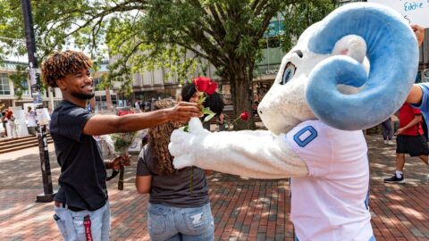 Student and RJ exchange a rose in the pit