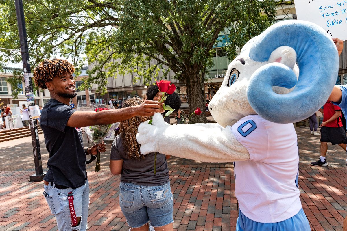 Student and RJ exchange a rose in the pit