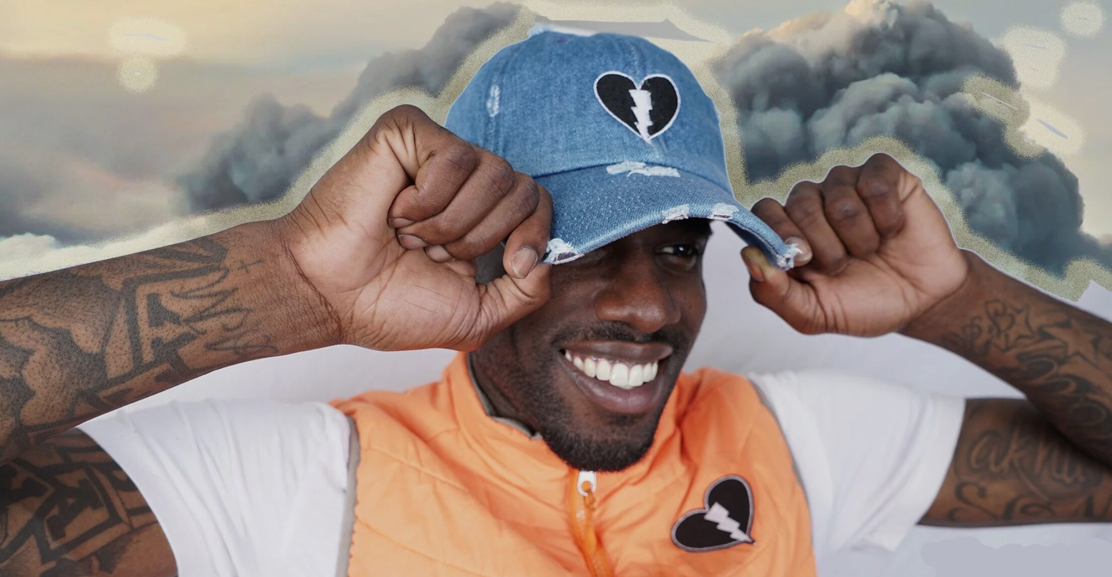 Smiling man tugs on a hat with a Live Black Heart logo on it.