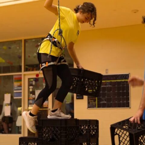 Student balances on milk crates at Campus Rec event