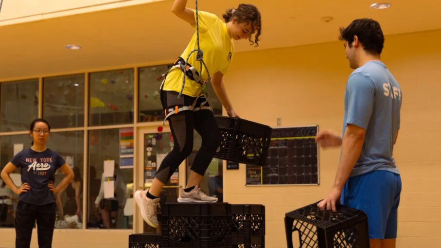 Student balances on milk crates at Campus Rec event